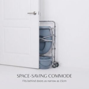 A white door is partially ajar, revealing the chrome and grey folding commode chair from image 1 in its compact, folded state, fitting into a narrow gap between the door and the wall, with a pail underneath. Text reads "SPACE-SAVING COMMODE: Fits behind doors as narrow as 15cm".