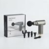Portable grey massage gun and its four attachment heads positioned next to the retail product box on a clean white background.